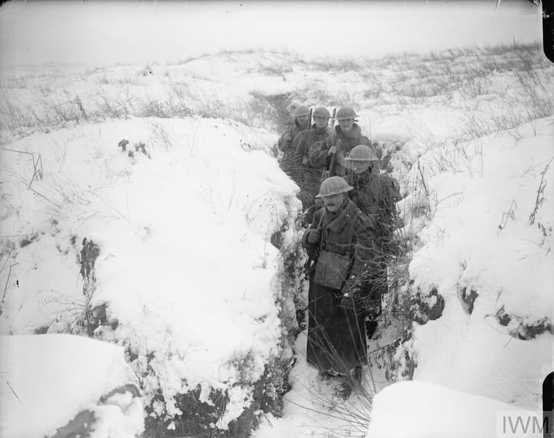 Troops coming out of a communication trench in the snow. © IWM (Q 4695)